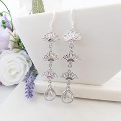 These silver crystal bridal earrings are the perfect statement earrings for your special occasion.  Featuring a stunning geometrical fan art deco design with clear crystals, these dangly earrings add a touch of vintage glamor to your look.  Whether you are attending a Gatsby party or a black-tie event, these earrings are sure to make an impression. 💖 Perfect for wedding shower, engagement party, rehearsal dinner or wedding day jewelry DETAILS : ◈ Earrings : 0.5  inch wide x 3 inch long (measured from top of ear wire) ◈ Materials : sterling silver ear wires, glass crystals, cubic zirconia stones ◈ Need a different color to match your wedding palette ➤ Send me a message for customization ✨For other silver Art Deco earrings, click here : https://www.etsy.com/shop/YsmDesigns?ref=shop-header-n Statement Earrings Silver, Earrings For Bride, Crystal Statement Earrings, Crystal Bridal Earrings, Wedding Day Jewelry, Silver Statement Earrings, Wedding Palette, Gatsby Wedding, Jewelry Details