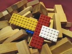 two legos are laying on top of each other in the middle of a pile of wooden blocks