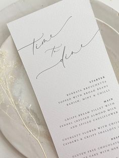 a white wedding menu card on a plate