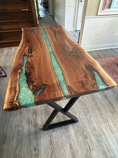 a table made out of wood with green paint on the top and black metal legs