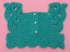 a crocheted green sweater with buttons on the front and back, against a pink background