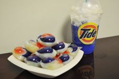 there is a bowl of jelly beans next to a cup of tide milkshake