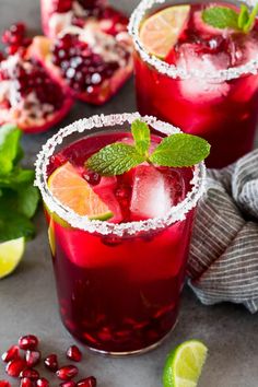 two glasses filled with pomegranate and garnished with mint