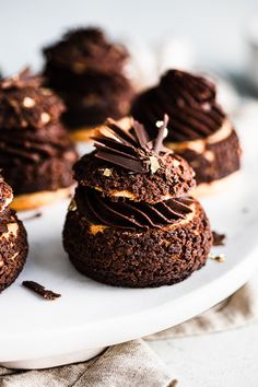 chocolate cupcakes with frosting and sprinkles on a white plate