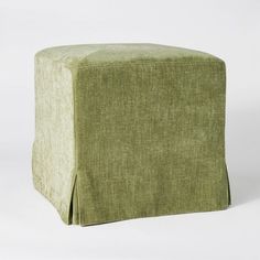 a green ottoman cover sitting on top of a white floor