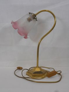 a lamp that is on top of a white surface with a light attached to it