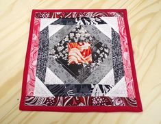 a red and black quilted placemat with an abstract design