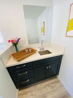 a kitchen with black cabinets and white counter tops