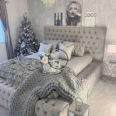 a bedroom with a large bed, chandelier and christmas tree in the corner