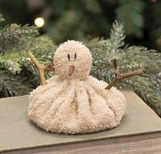 an octopus stuffed animal sitting on top of a book next to a christmas ornament