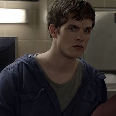 a young man standing in a bathroom next to a sink