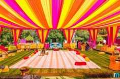 an outdoor event with yellow and pink draping