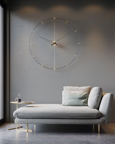 a white couch sitting in front of a large clock on the side of a wall