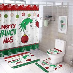 a bathroom decorated for christmas with the grin on it's shower curtain and toilet cover