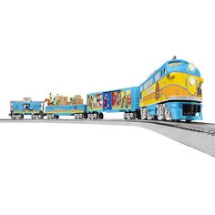 a blue and yellow toy train with cartoon characters on the front is going down the track