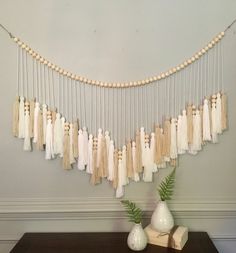 a table with some vases on top of it and string hanging from the wall