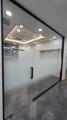 an empty office with glass walls and doors