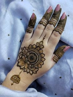 a woman's hand with henna tattoos on it