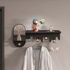 there is a coat rack with headphones on it and a mirror above the coat rack