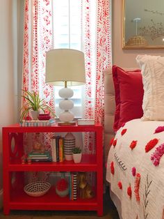 a bedroom with red and white decor on the bed