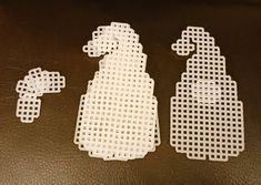 three pieces of white plastic sitting next to each other on a brown surface with holes in the middle