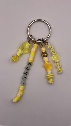 a yellow and white keychain that has some beads on it