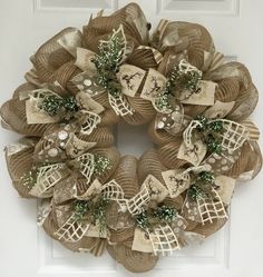 a wreath made out of burlock and mesh with bows on it's sides