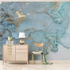 a blue and gold marble wall mural in a living room with a lamp on the side table