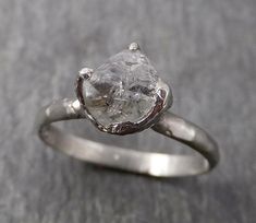 a white diamond ring sitting on top of a table