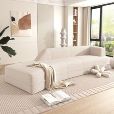 a white couch sitting on top of a hard wood floor next to a book shelf