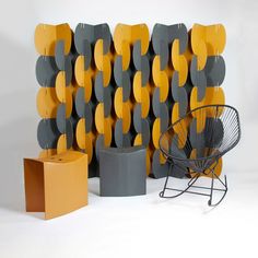 a chair sitting next to a wall with yellow and gray circles on it's sides