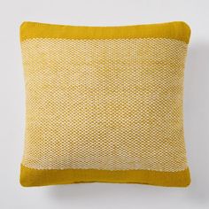 a yellow and white pillow sitting on top of a wall