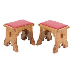 a pair of wooden benches with red cushions