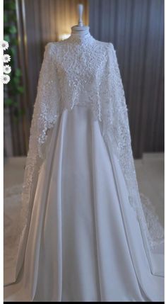 a white wedding dress with long sleeves on display