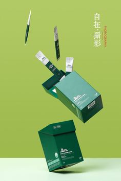 a green box with scissors flying out of it and some papers in the air above