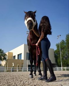 two girls standing next to a horse with a bridle on it's head