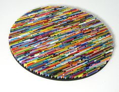 a circular artwork made out of many different colored pencils on a white surface,