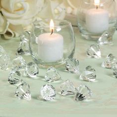 two candles and some crystal pieces on a table