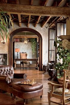 a living room filled with furniture and lots of plants on top of wooden flooring