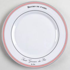 a white plate with red trim and writing on the rim reads bistro de paris