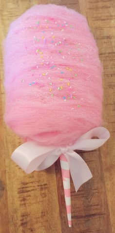 a pink lollipop with sprinkles on it and a candy cane