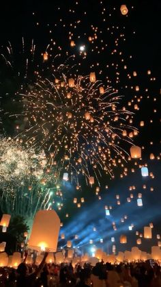 the sky is filled with floating lanterns as people watch