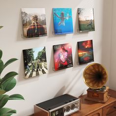 there are many pictures hanging on the wall next to a record player and an alarm clock