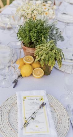 the table is set with lemons and greenery