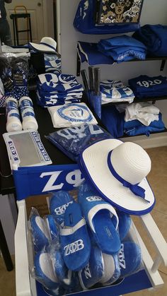 blue and white items are on display in a store with hats, scarves and shirts