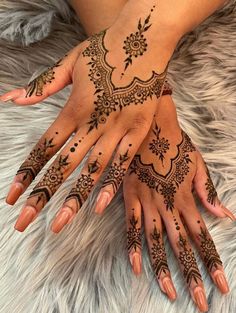 two hands with henna tattoos on them