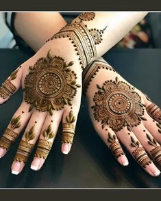 two hands with henna designs on them