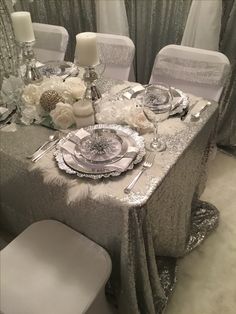 the table is set with silver and white decorations