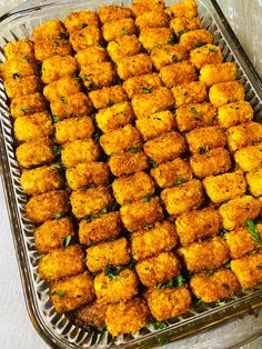 a tray filled with tater tots sitting on top of a wooden table