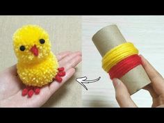 a small yellow bird sitting on top of a piece of yarn next to a roll of thread